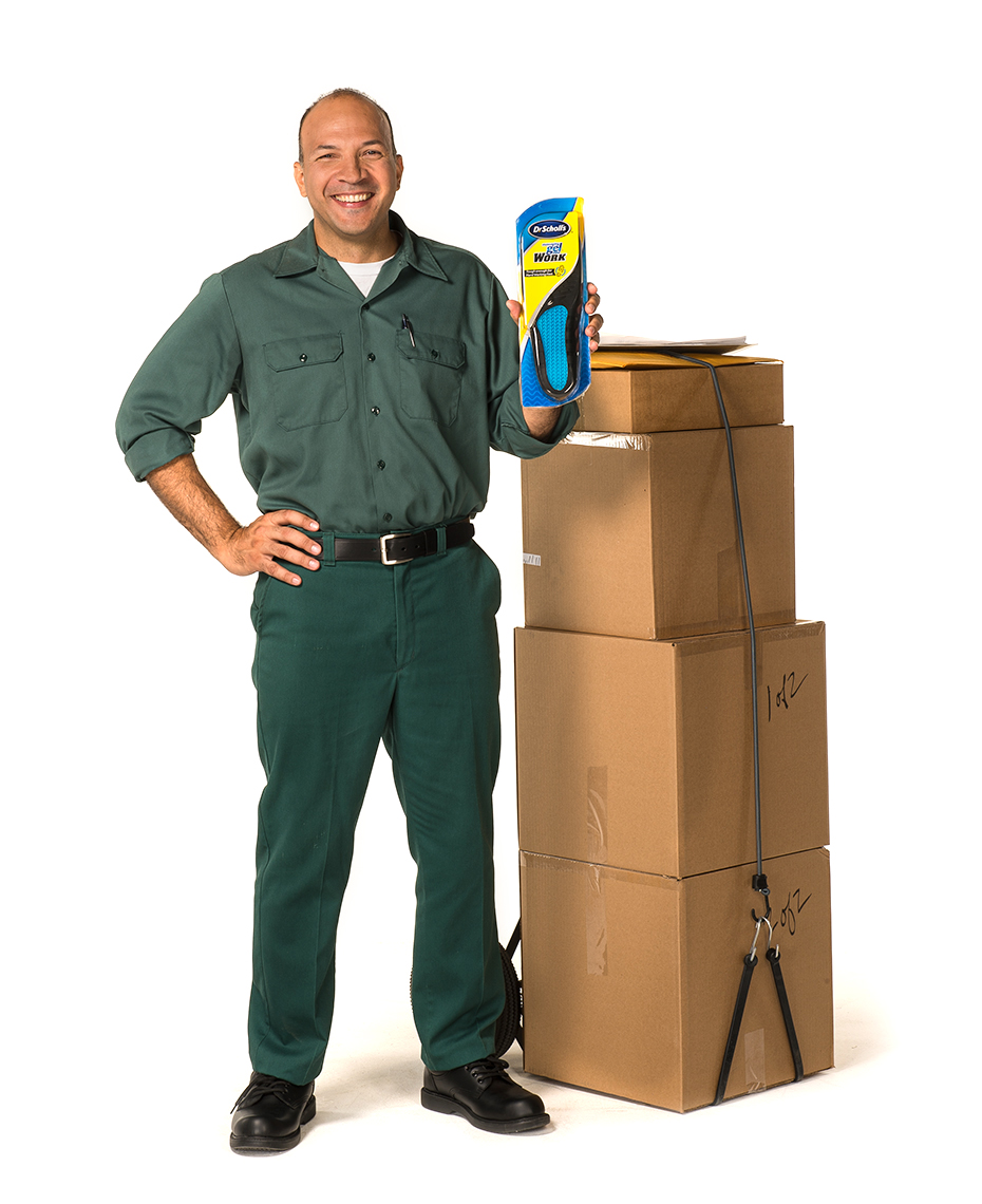 Delivery man stands with boxes holding product for Dr. Scholl