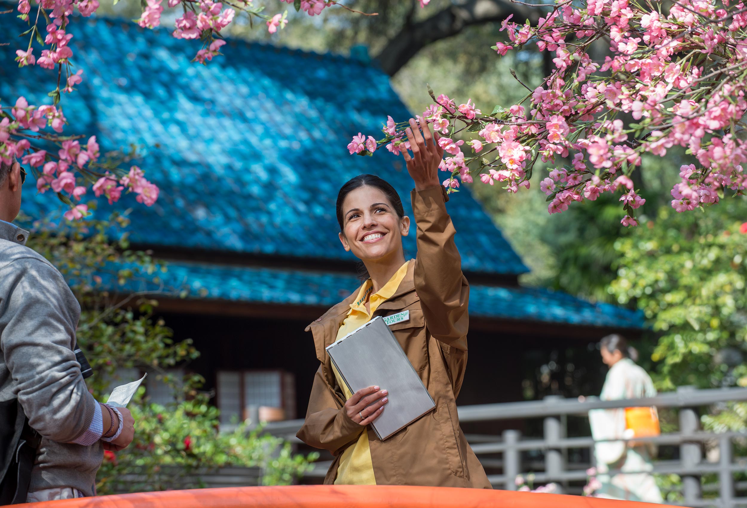 Tour guide smells  apple blossoms in Chinese garden for lifestyle advertising campaign for Claritin D