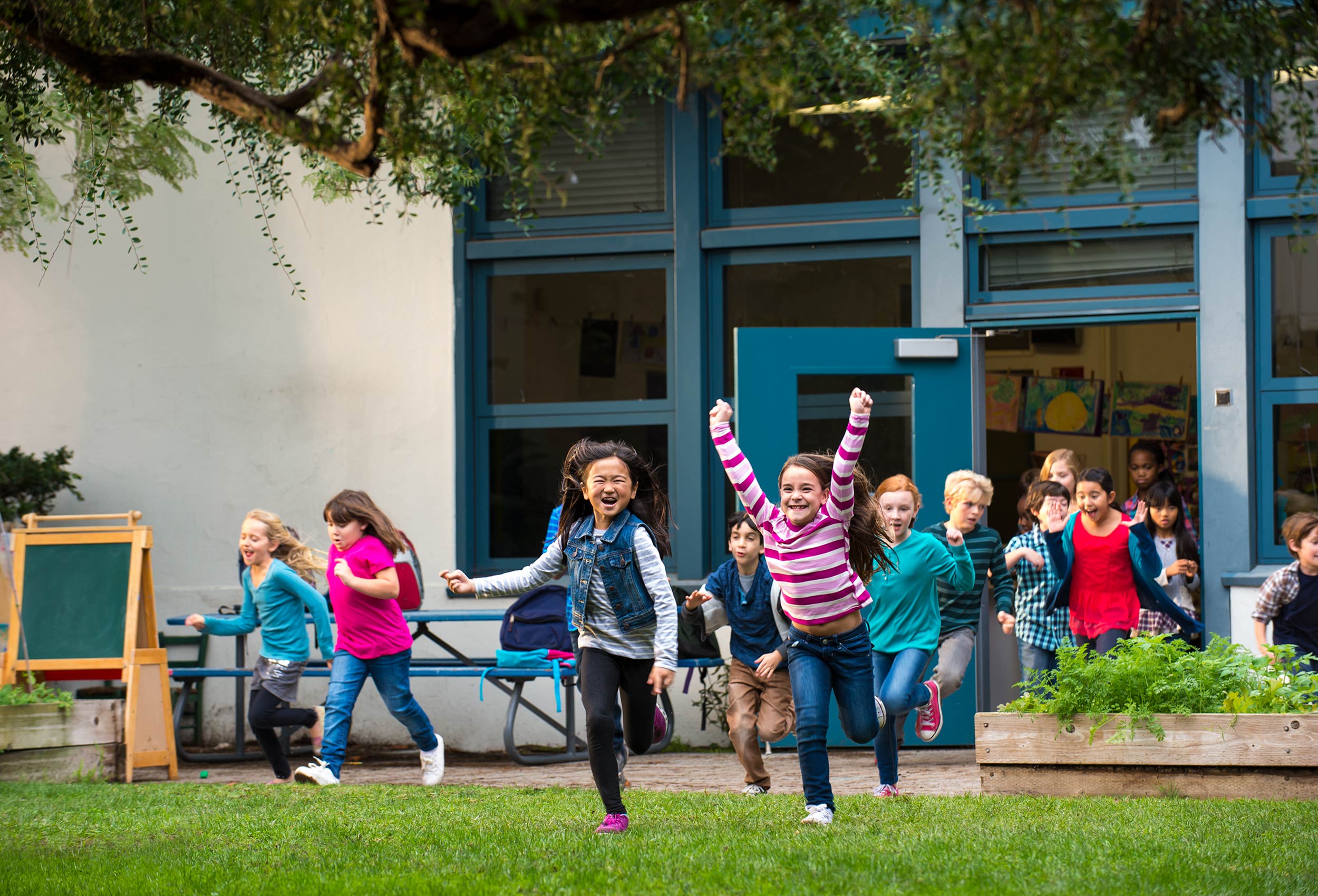 Happy students run out of school room for recess for Children