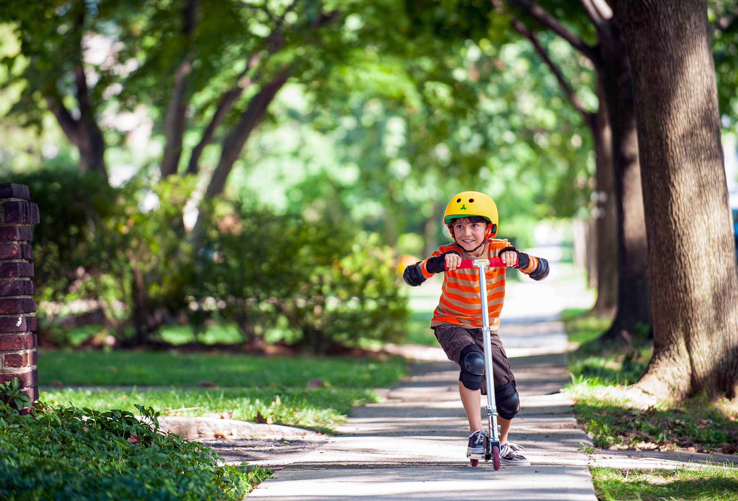 Boy rides scooter in suburbs - lifestyle advertising campaign for Children