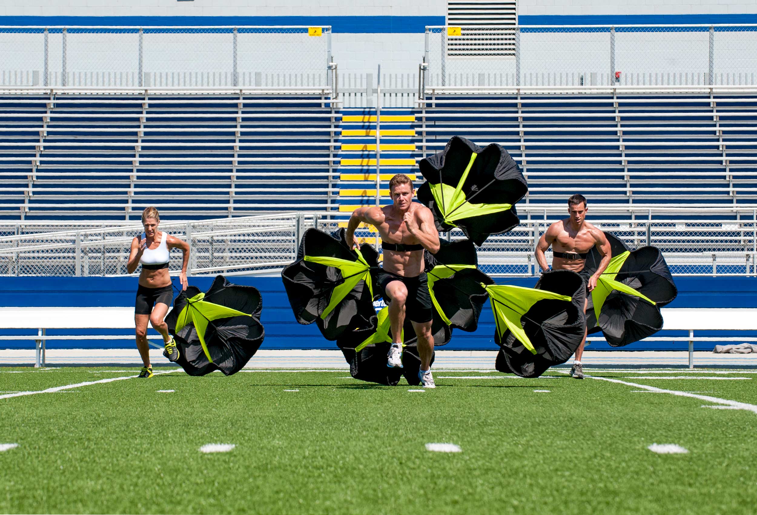 Coppertone Sport Pro athletes run across football field with speed resistant parachutes 