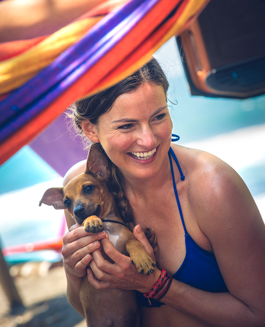 Surfer girl holds stray dog in Costa Rica - lifestyle advertising for Coppertone Sport sunscreen