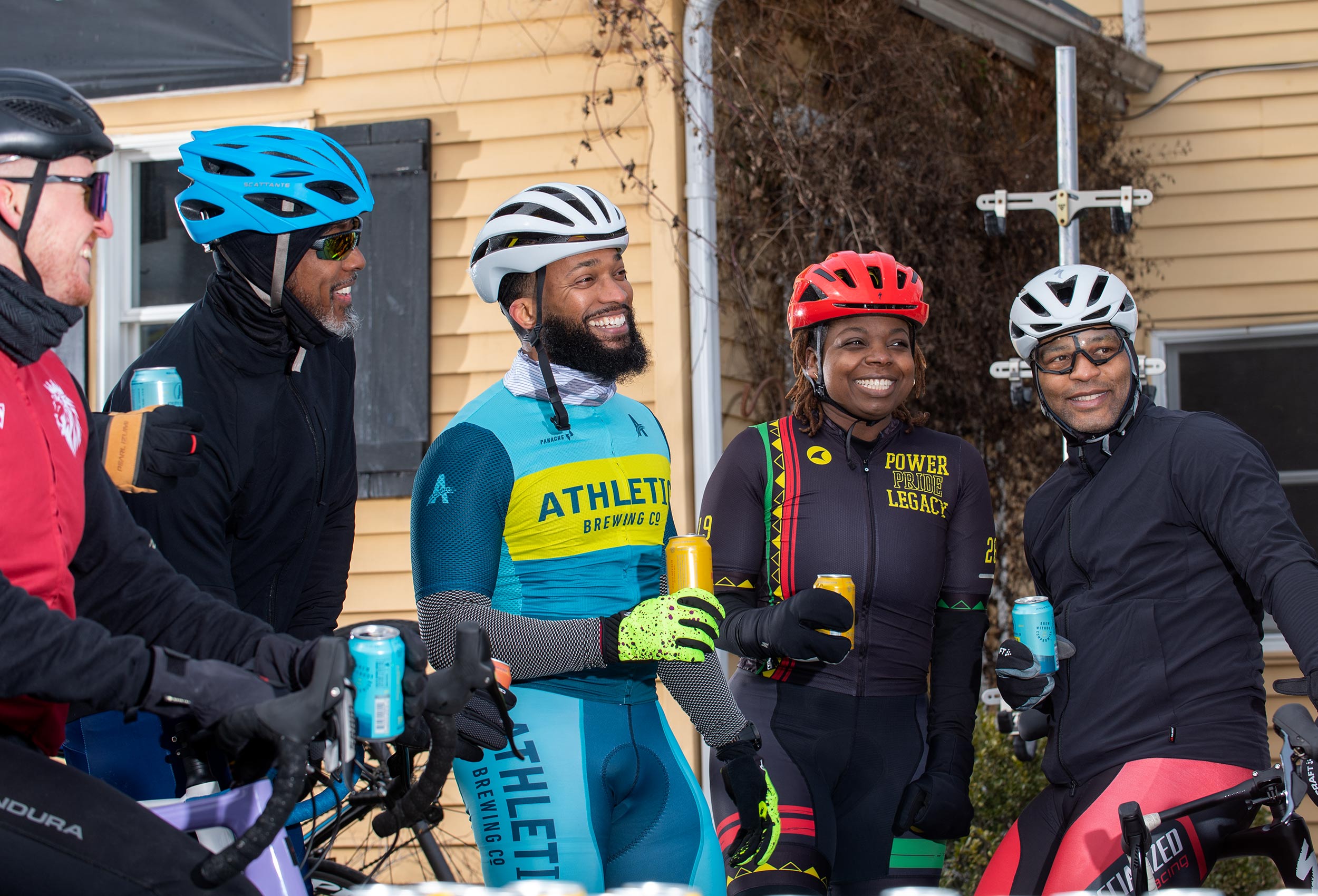 Ambassador Anthony Cooper-Jenkins drinks non-alcoholic beer with cyclist friends - advertising for Athletic Brewing Co.