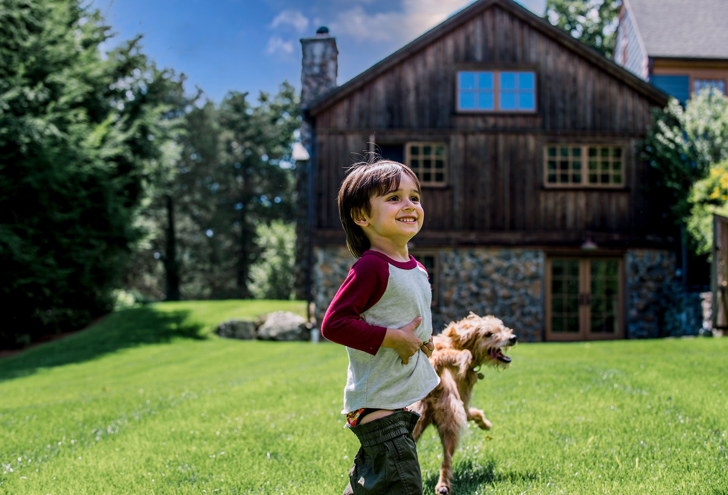 Little boy play on green lawn with dog