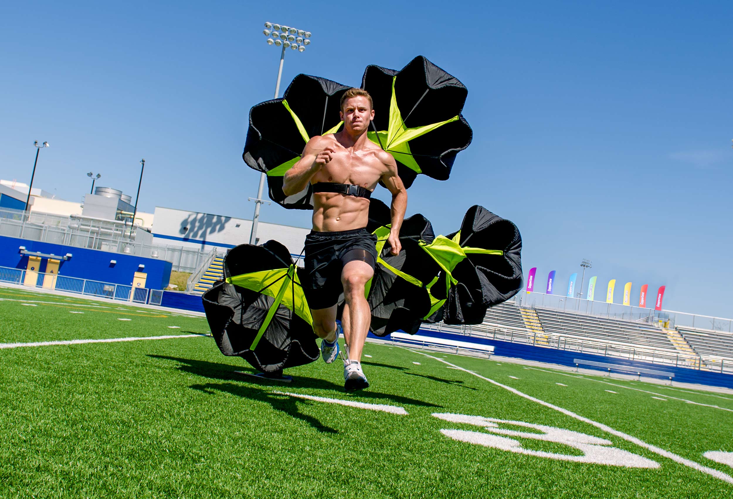 Coppertone Pro athletes Jonathan Collins runs across football field with speed resistant parachute 