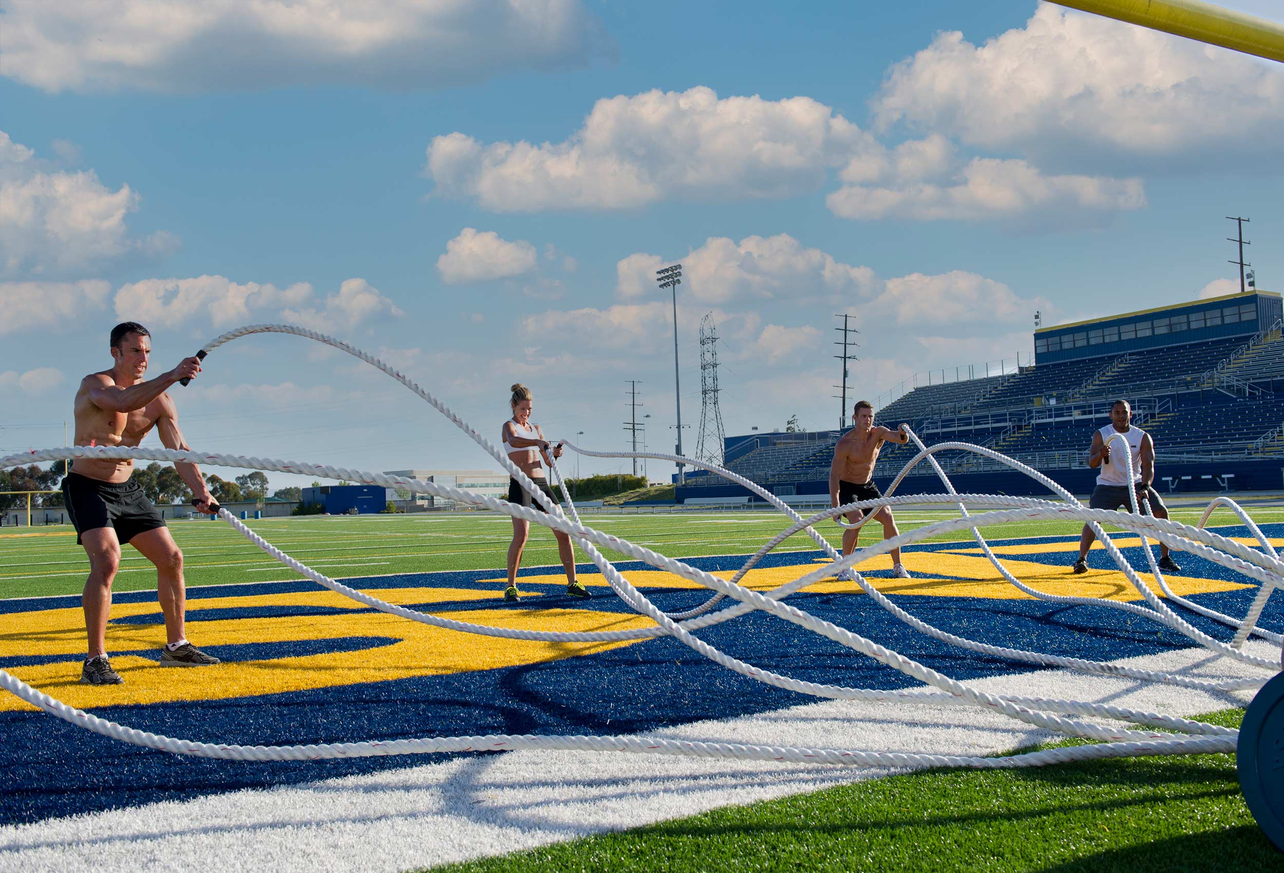 Group of Coppertone Sport Pro athletes workout with ropes in football stadium