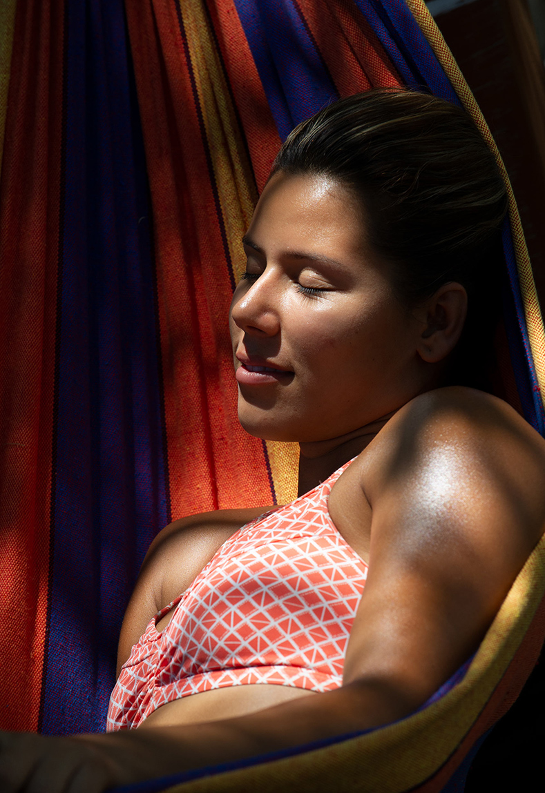 Costa Rican girl lays in hammock in sun
