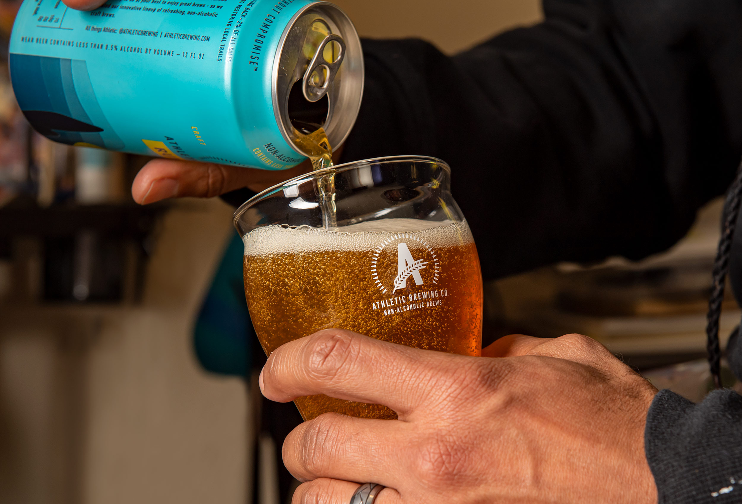 Close up pouring can of Run Wild non-alcoholic beer into beer glass