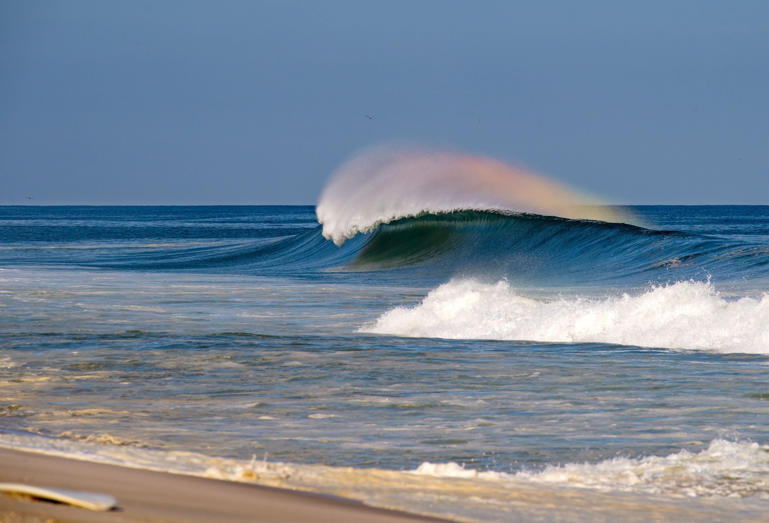 West wind makes a rainbow in the spray on wave in Seaside Heights, NJ.