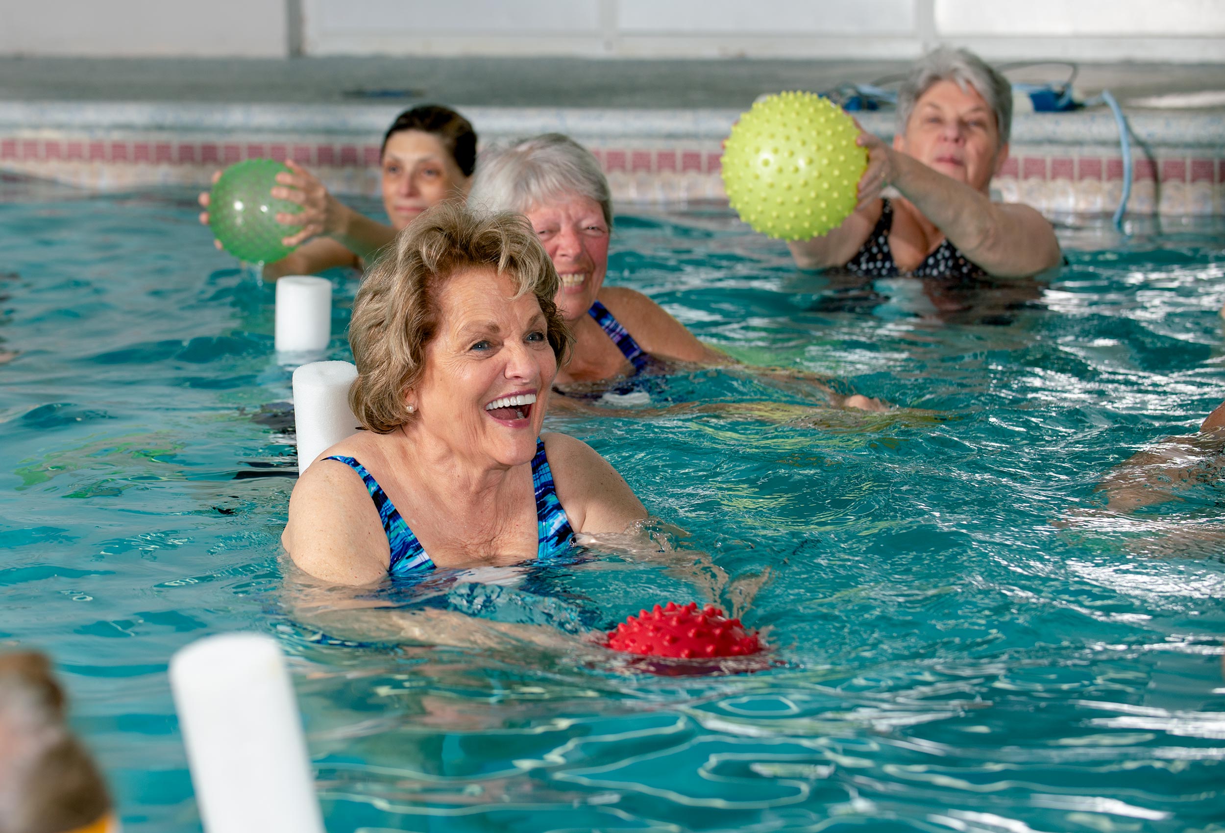 Seniors health and wellness water aerobics class at indoor pool 