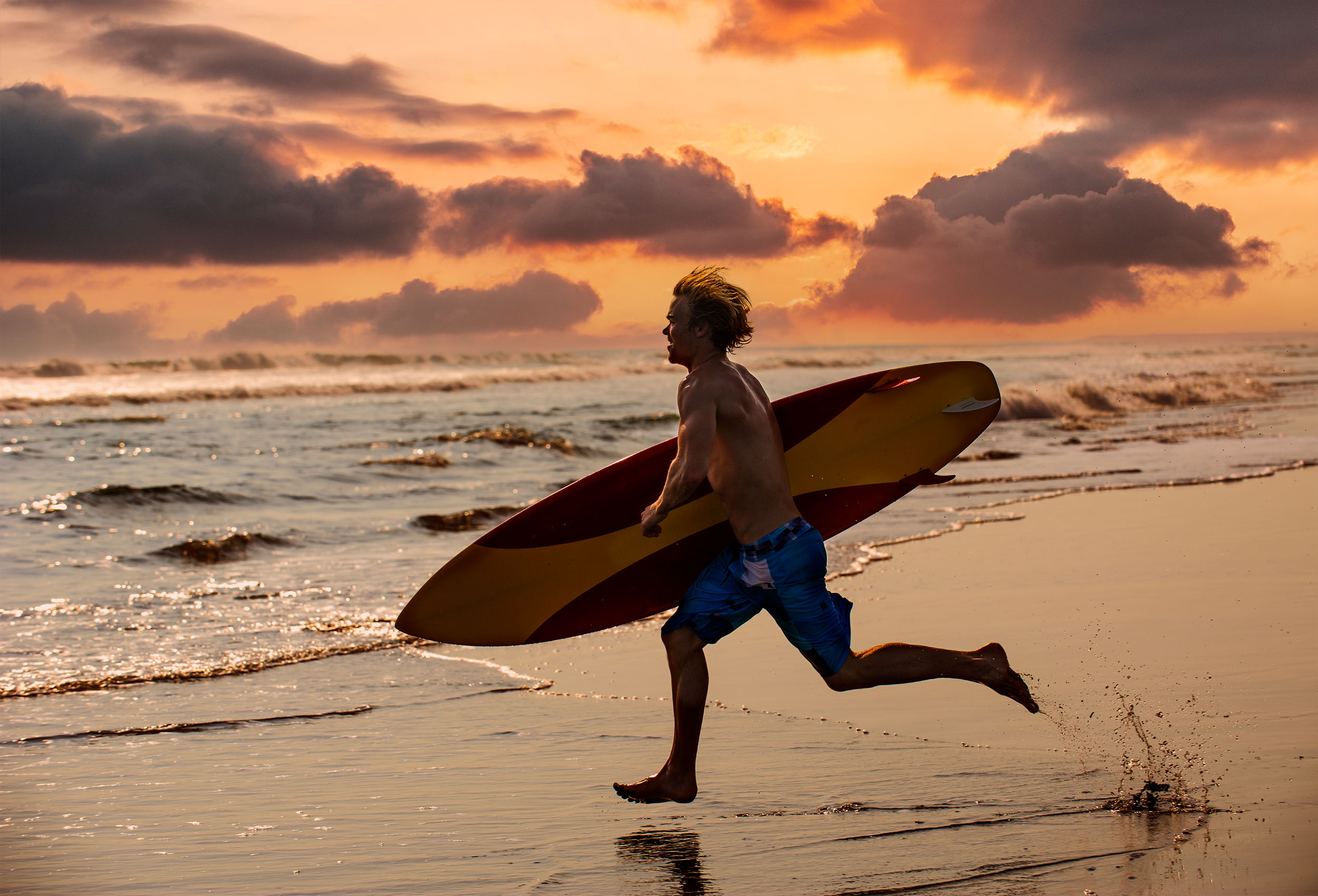 Surfer runs into ocean in Costa Rica  at sunset for Coppertone Sport Embrace the Sun advertising