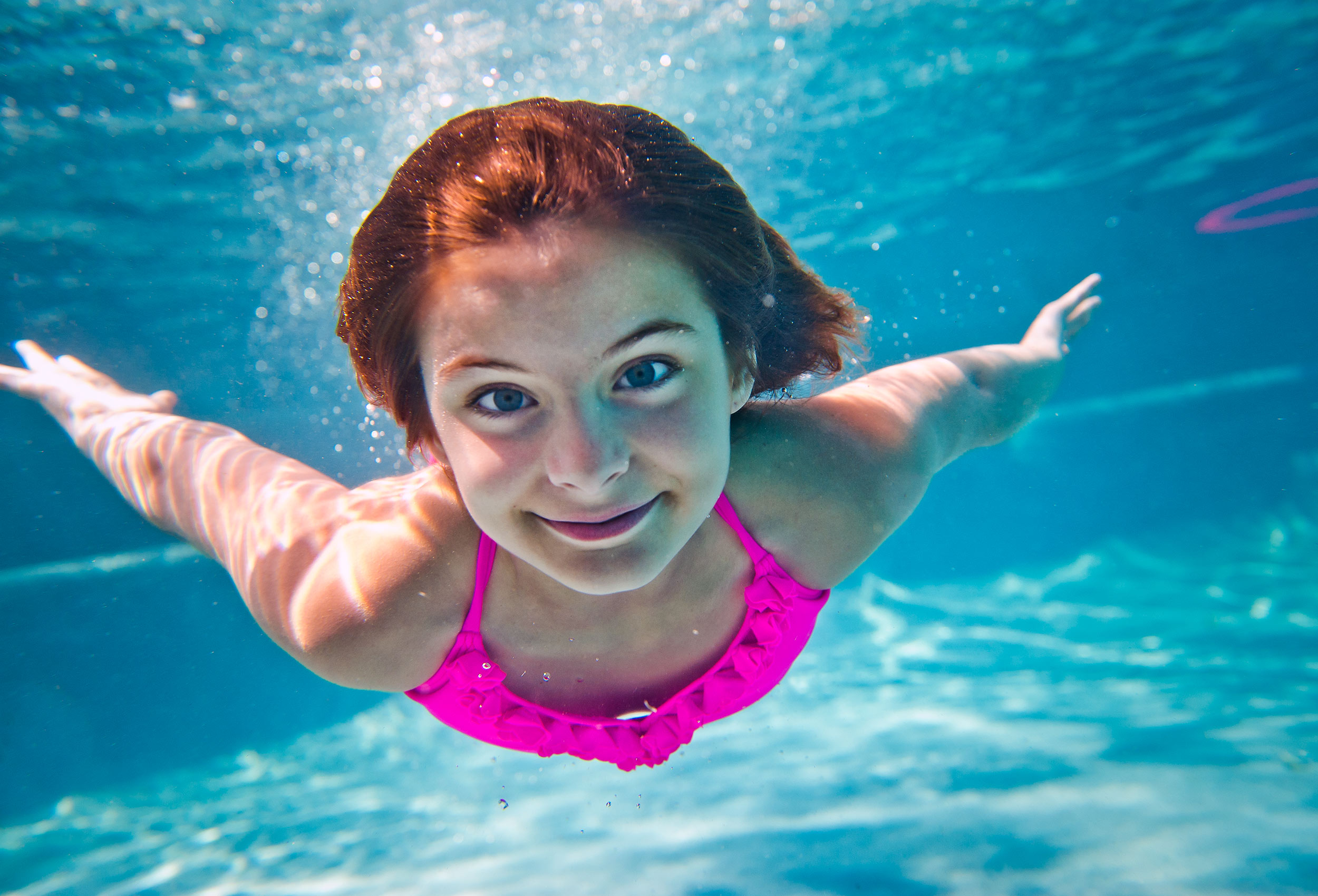  Young girl in pink bathing suit swims underwater for Coppertone Wet